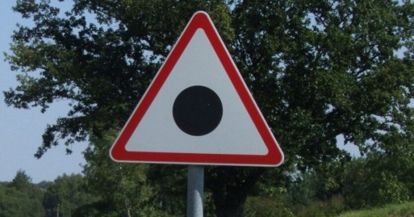 Черная точка в треугольнике на дорожном знаке