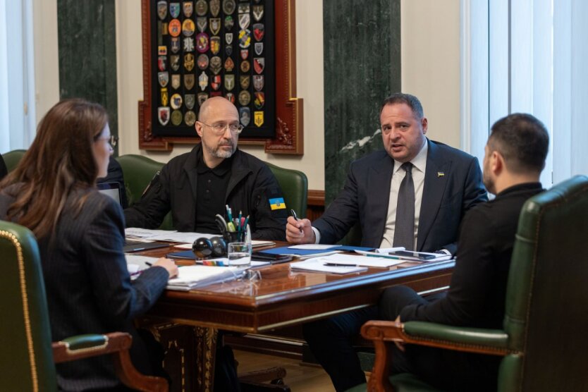 Зеленский рассматривает бумаги у стола