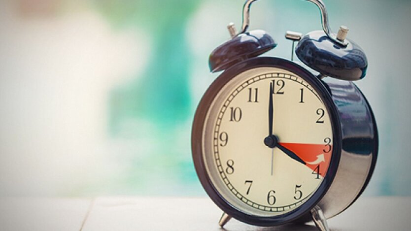 Рука, перекладаючи годинник на літній час.